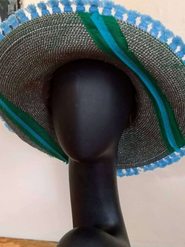 Straw hat with a blue flower and green and blue trim.