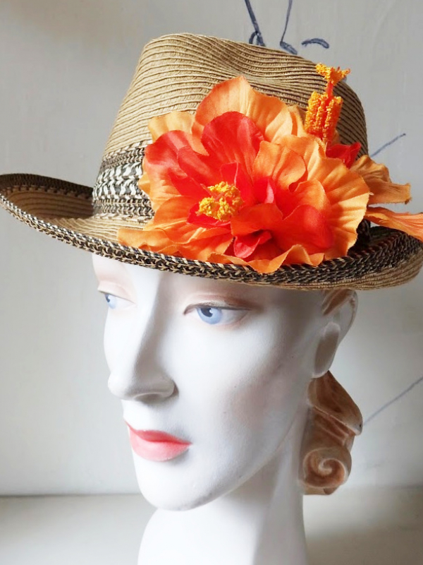A straw hat with an orange flower.