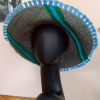 Straw hat with a blue flower and green and blue trim.