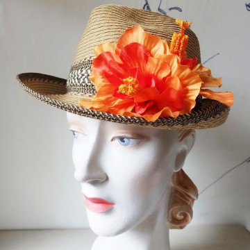 A straw hat with an orange flower.